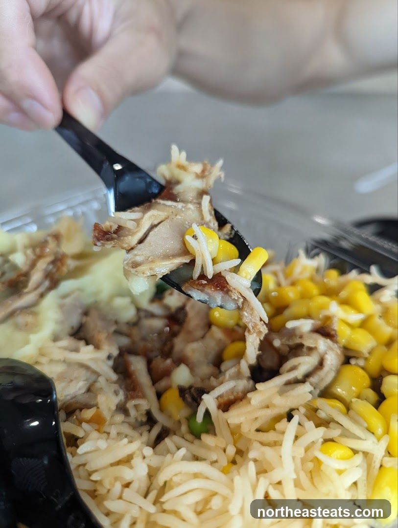 Close-up of a meal with rice, corn, and meat