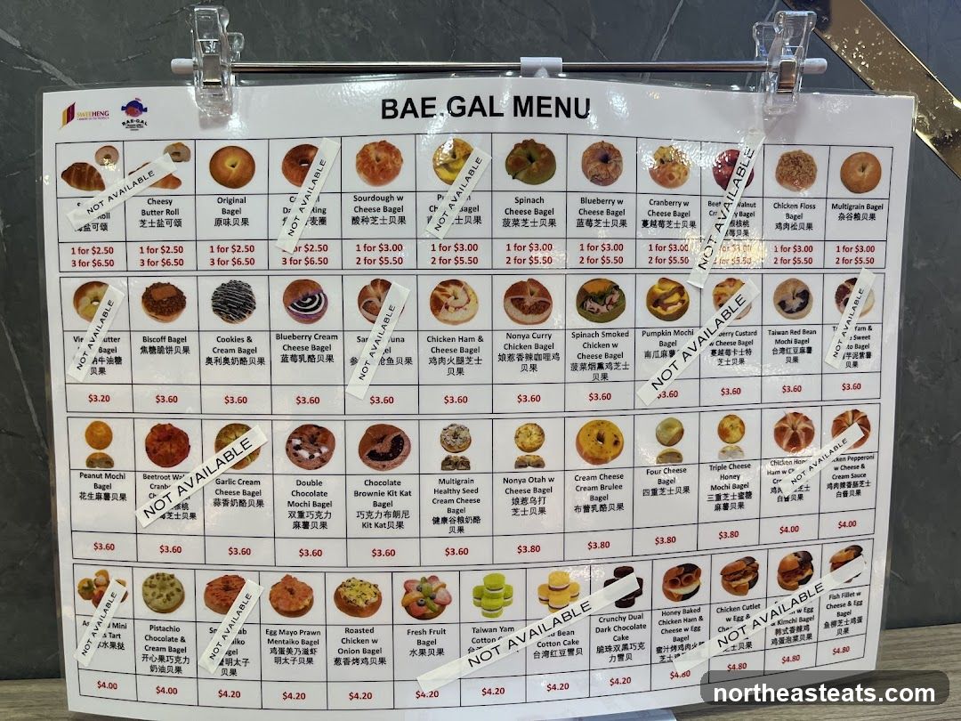 A menu board displaying various types of bagels with images and prices. Some items are marked as 'NOT AVAILABLE'.