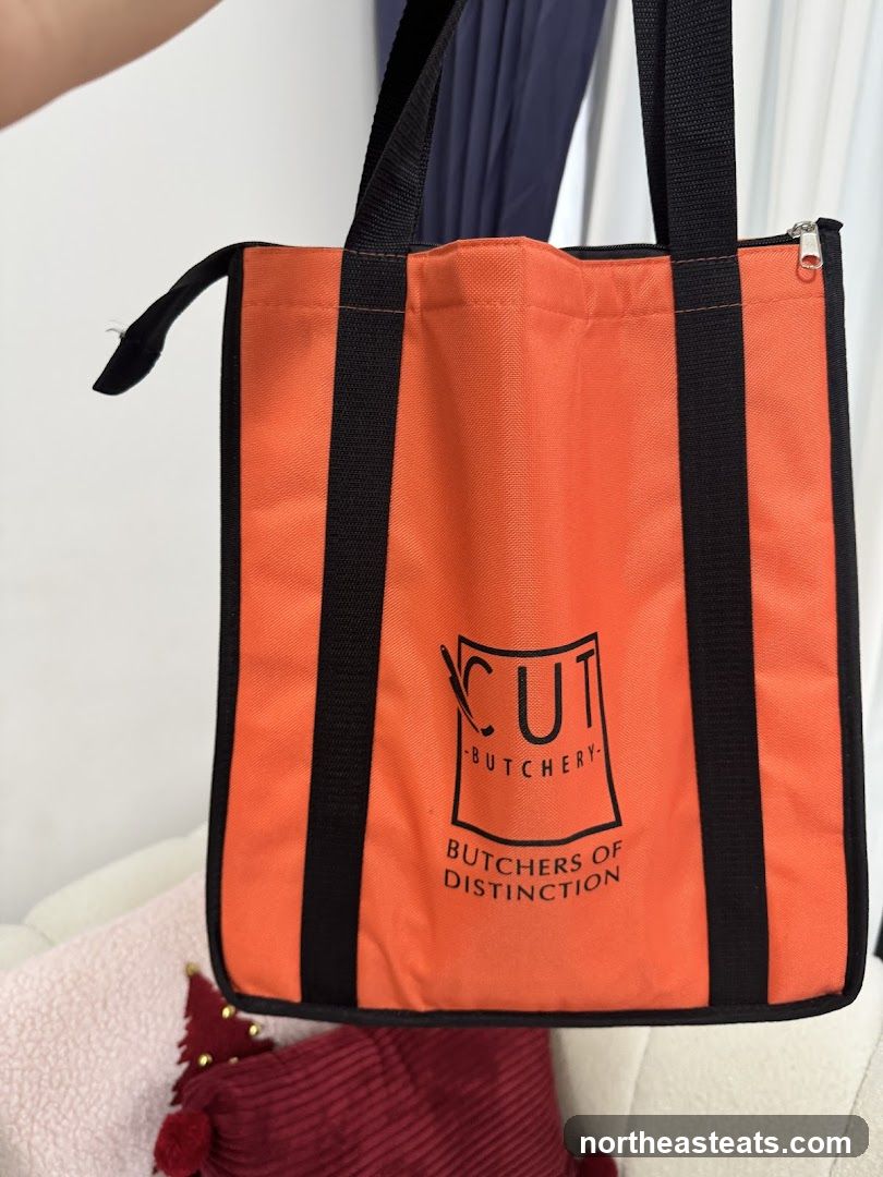 Orange tote bag with butcher shop logo