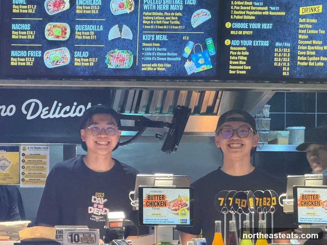 Two employees smiling behind a counter