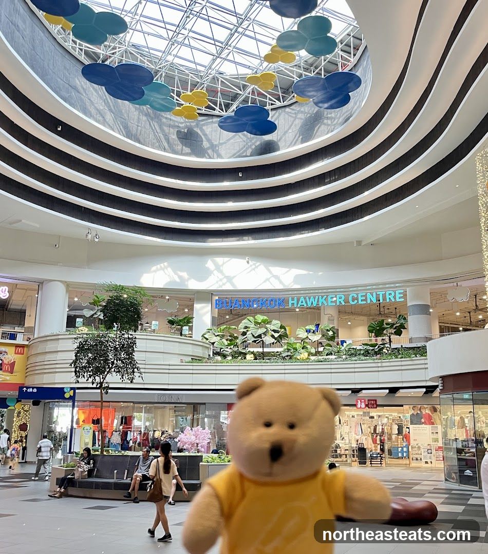 Interior of a shopping mall with a teddy bear in the foreground
