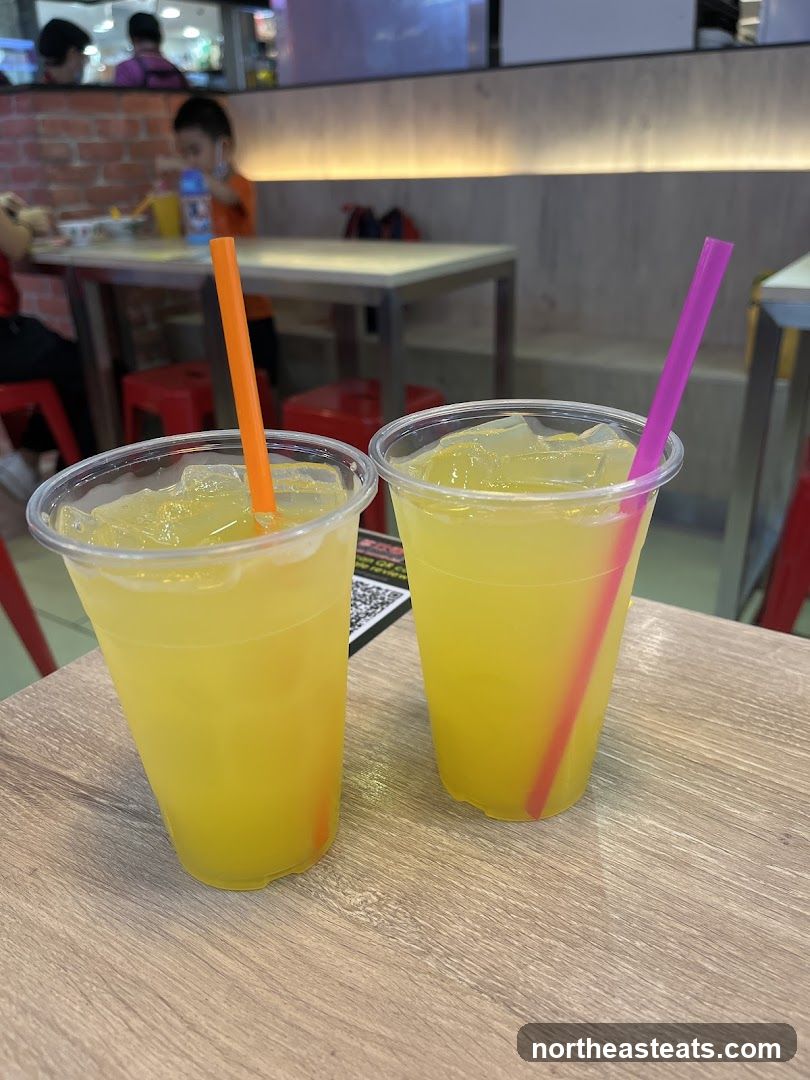 Two yellow drinks with straws