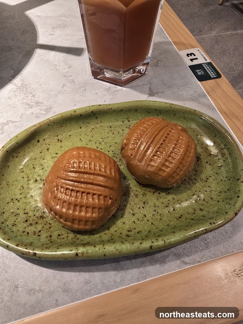 Two pastries on a green plate with a drink