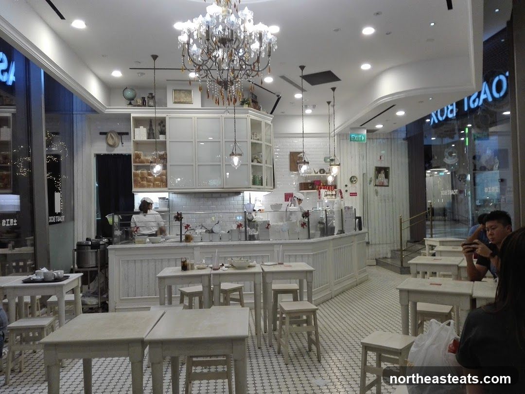 Interior of a cafe with white tables and chairs