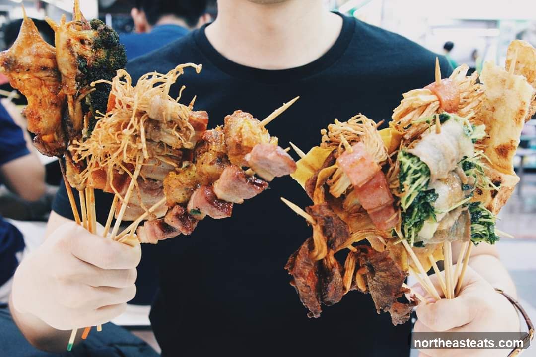 Person holding skewers of food