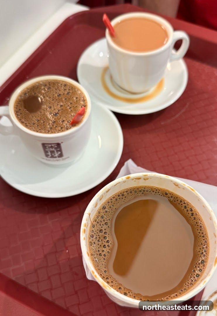 Three cups of coffee and tea on a tray