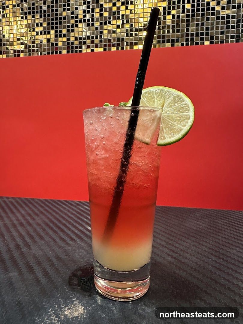 Pink layered drink with lime and straw