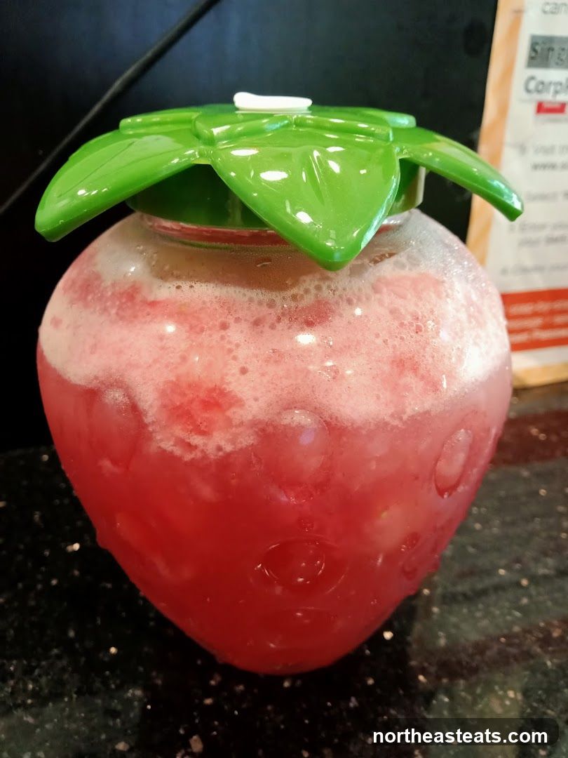Strawberry-shaped pitcher with pink beverage