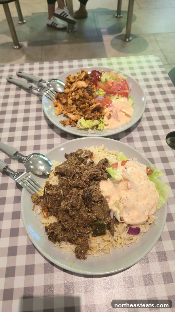 Two plates of food on a checkered tablecloth