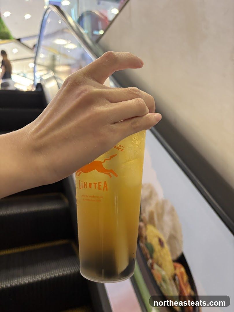 Hand holding a drink with a logo