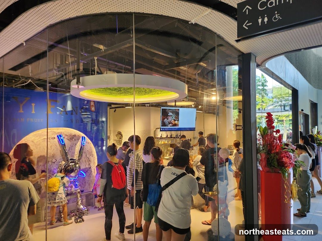 People inside a store with a large moon and rabbit sculpture