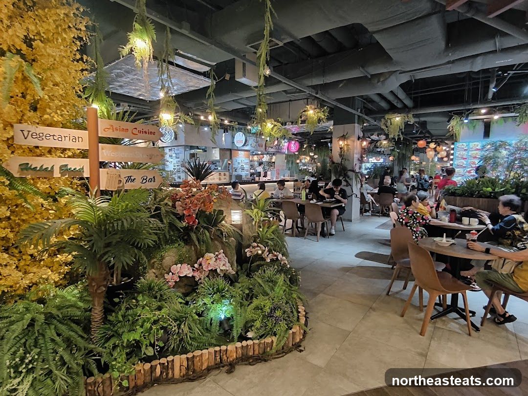 Food court with lush greenery and directional signs