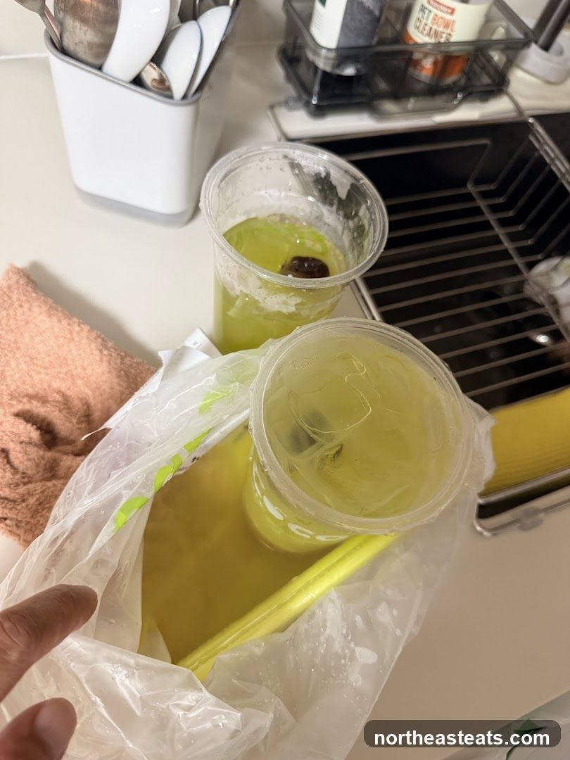 Two green drinks in plastic cups