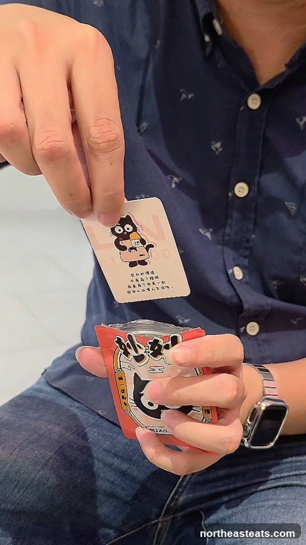Person holding a card and a snack bag