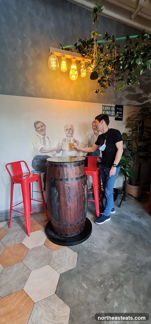 Man holding a beer at a barrel table