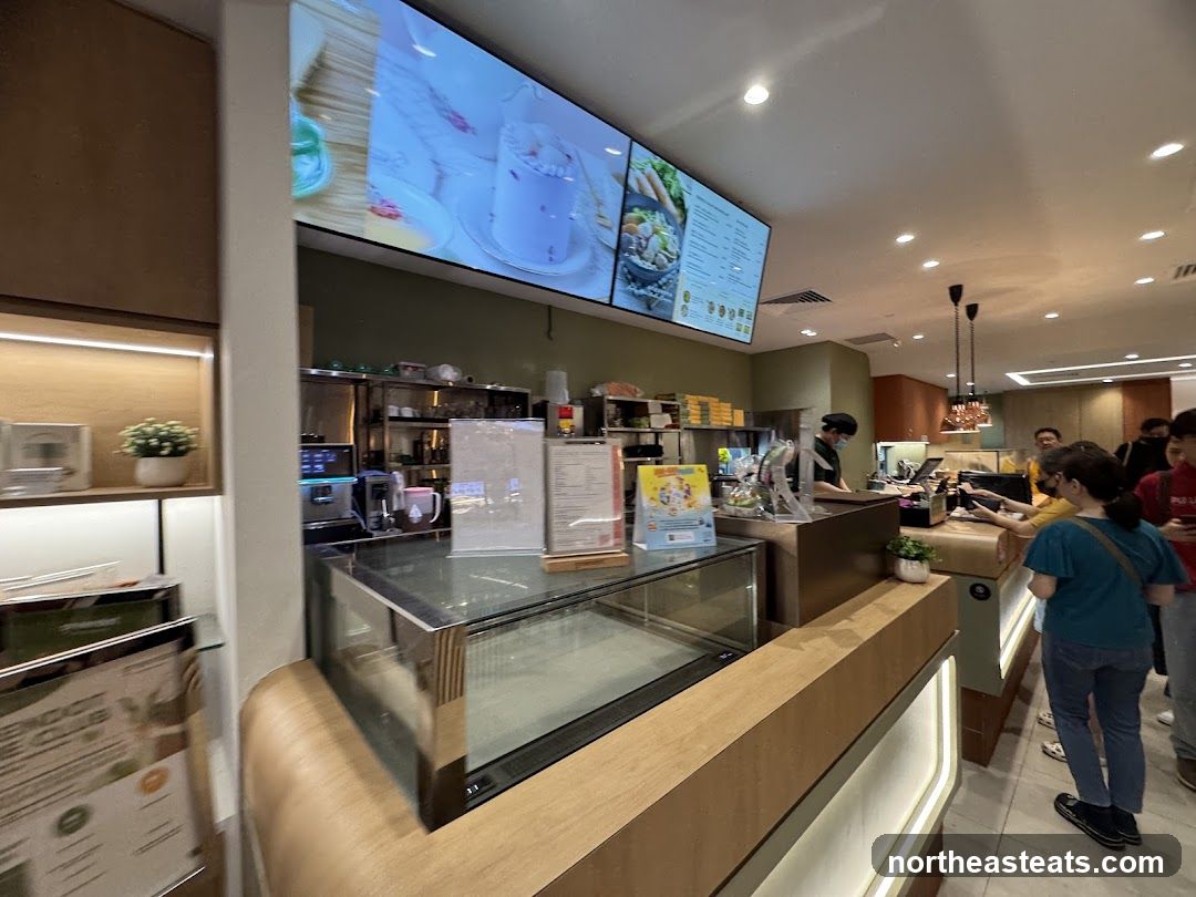 Cafe counter with digital menu and customers