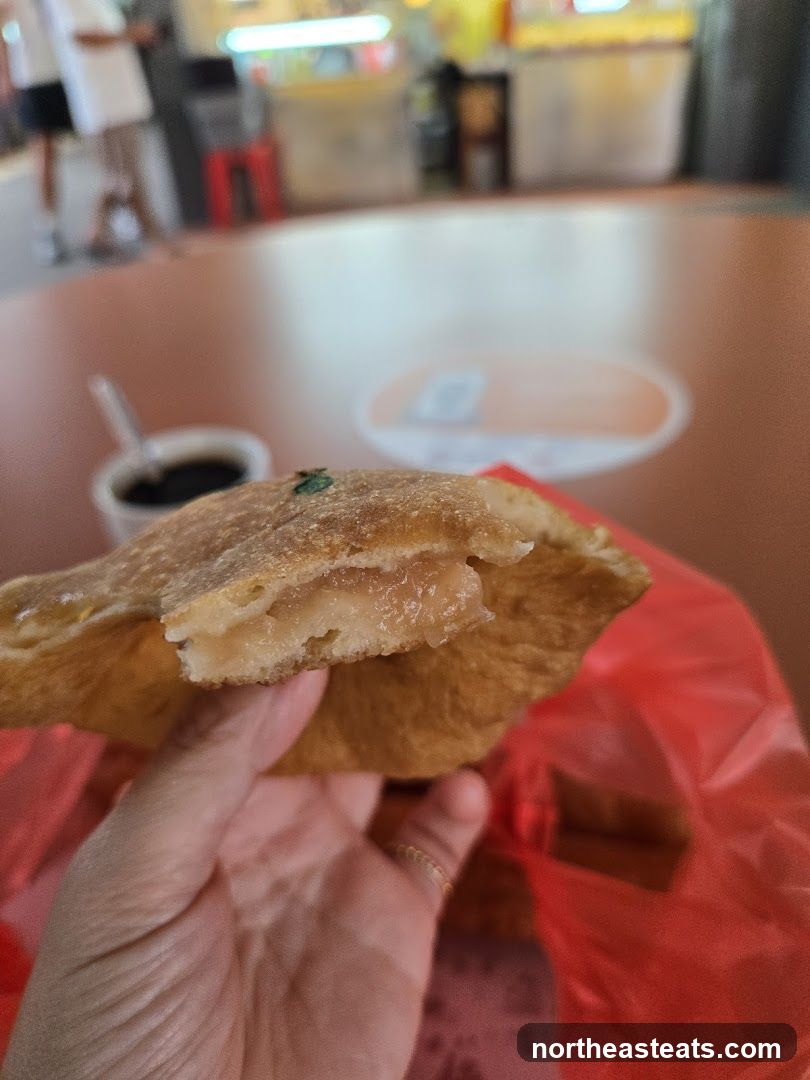 Hand holding a pastry with filling