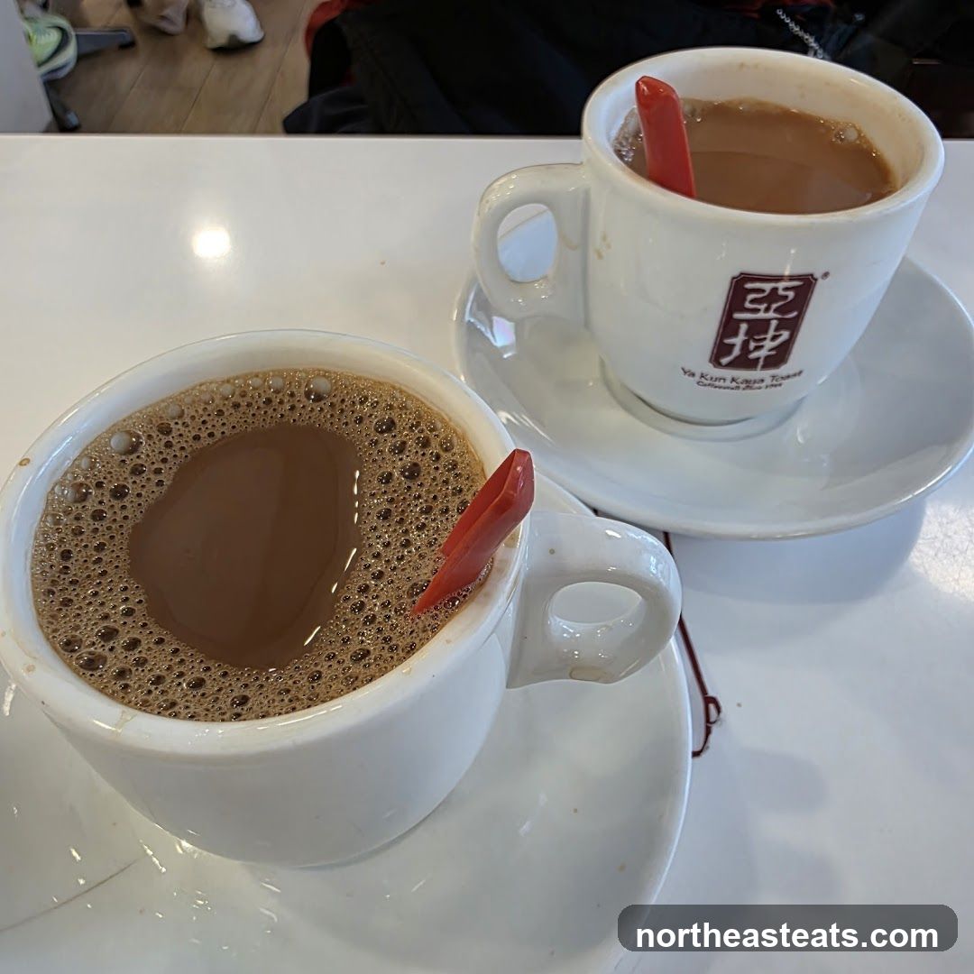 Two cups of coffee with red stirrers