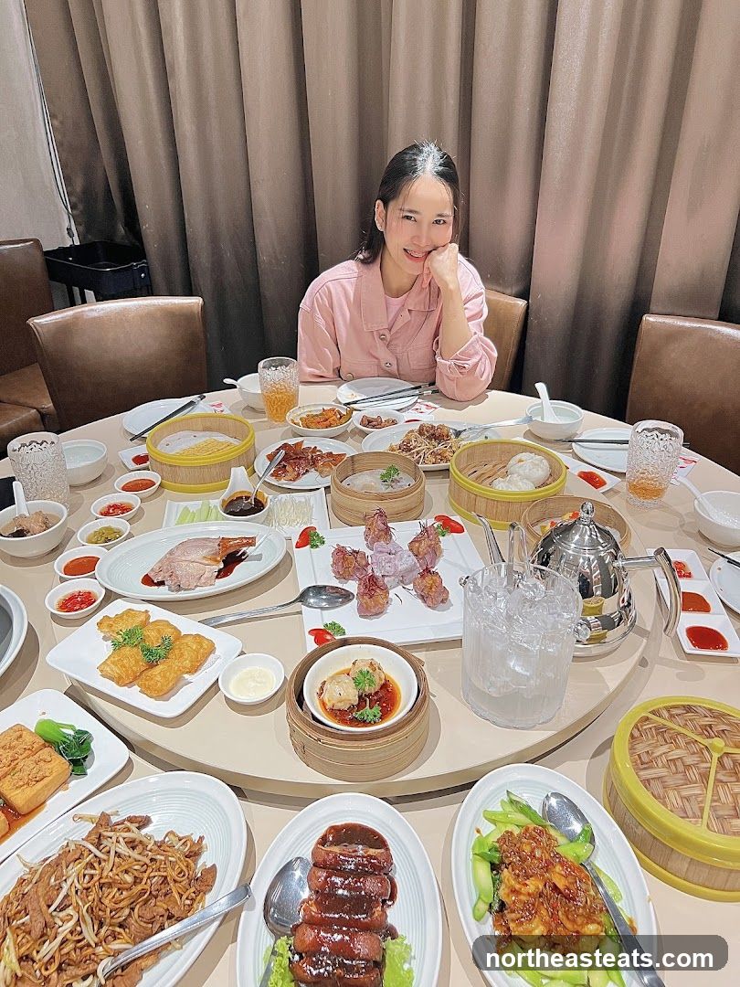 Woman Posing at a Table Laden with Chinese Food