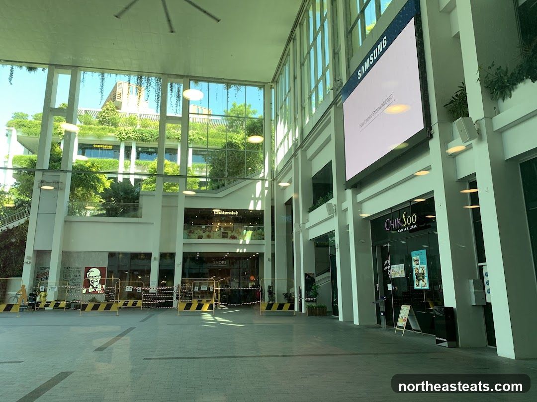 Indoor shopping mall with greenery and digital displays
