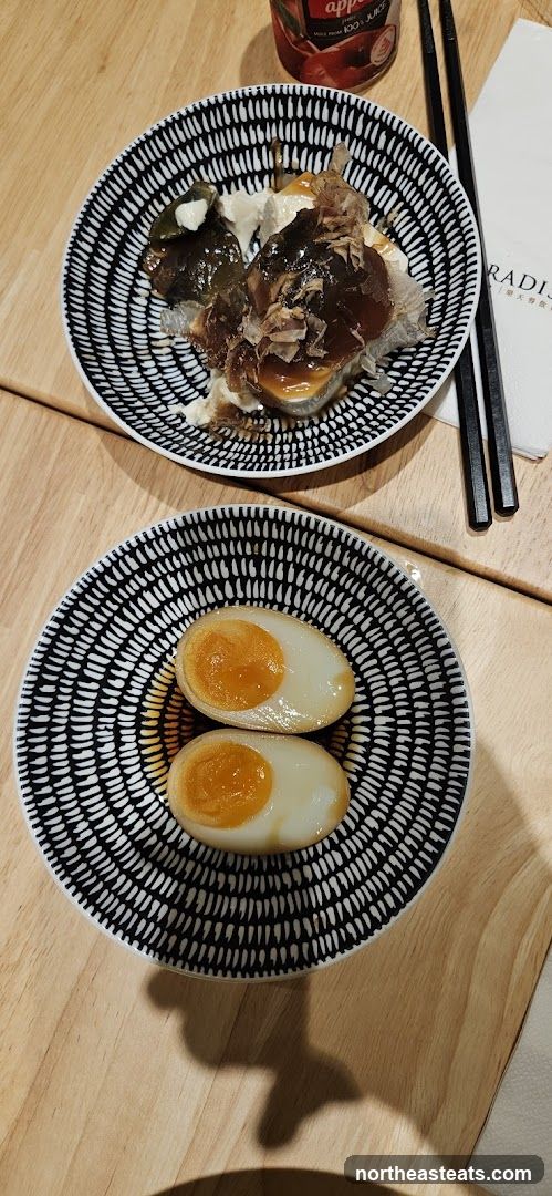 Two plates of food with a bottle of juice