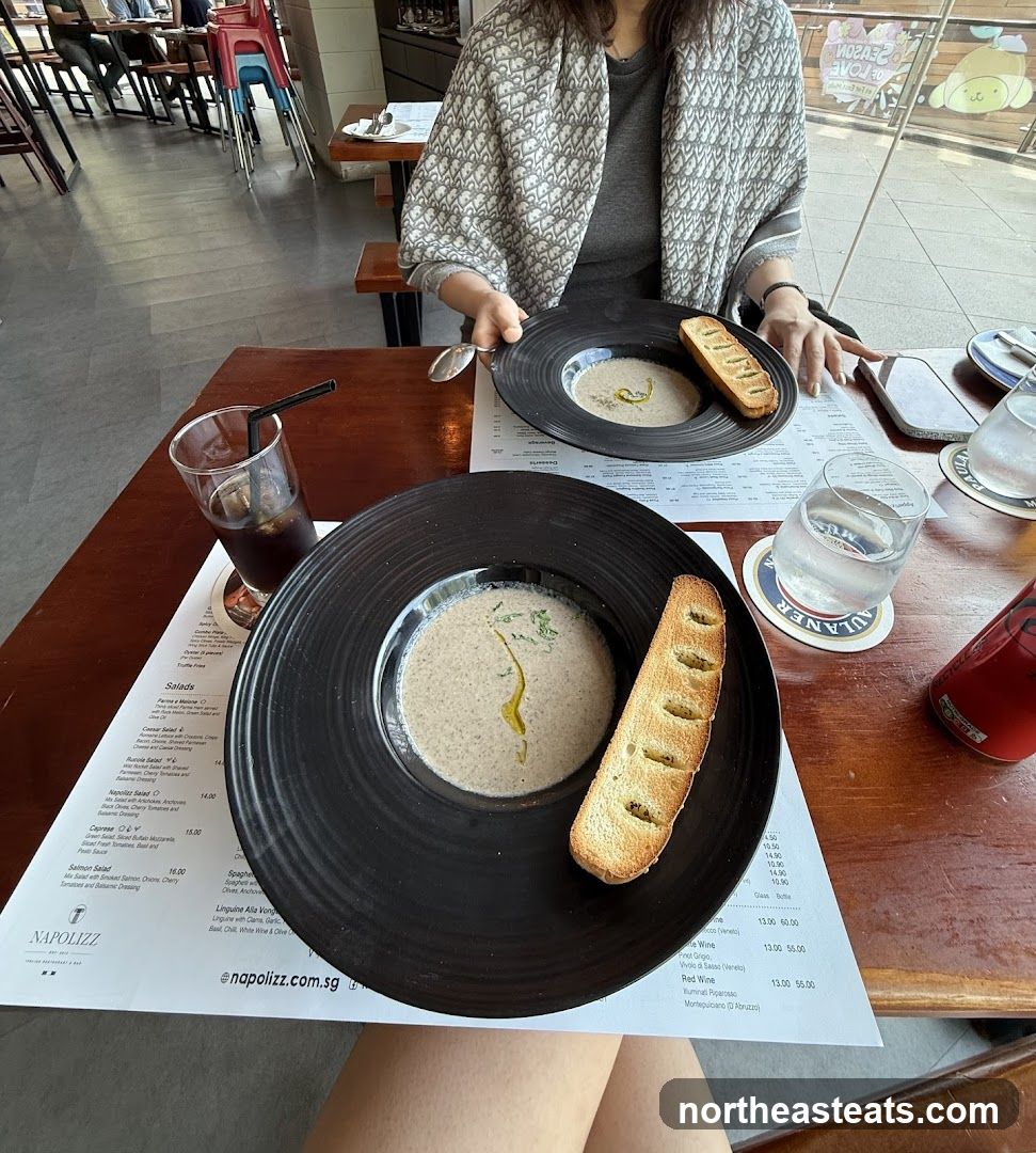 Two bowls of mushroom soup with bread