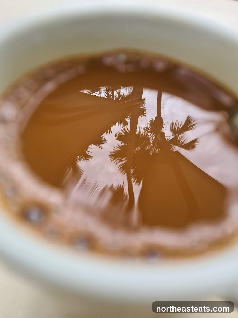 Reflection of palm trees in a cup of coffee