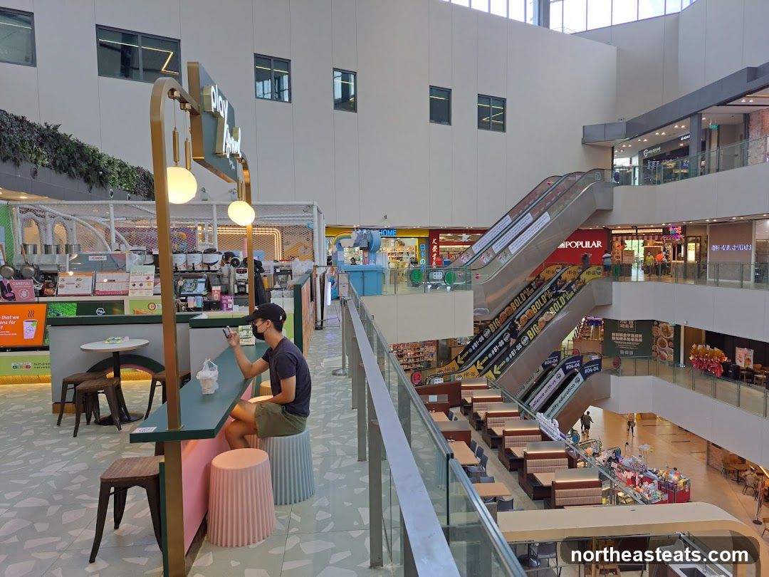 Indoor shopping mall with escalators and shops