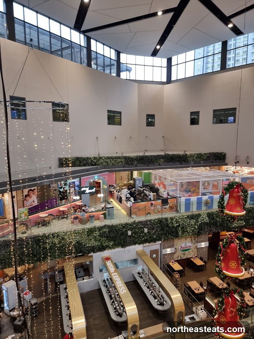 Indoor shopping mall atrium with restaurants and play area