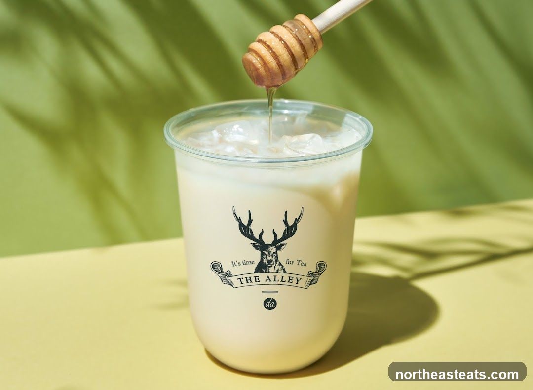 A drink with honey being drizzled in.