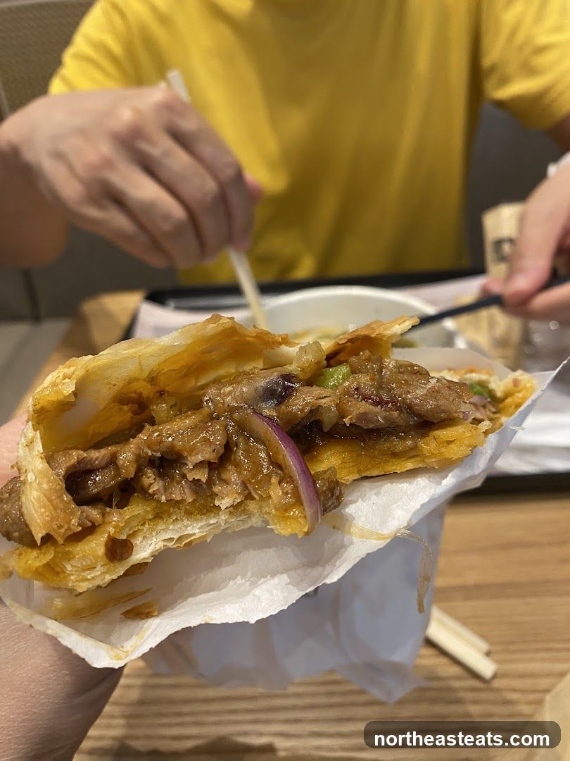 Close-up of a savory pastry filled with meat and onions