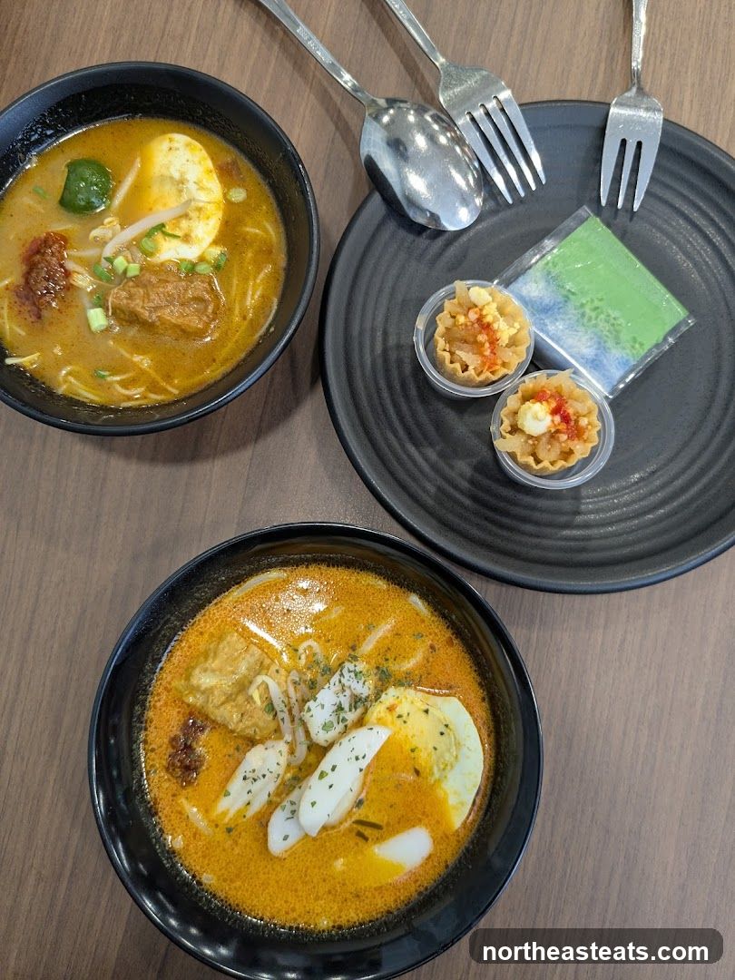 Two bowls of laksa with side dishes