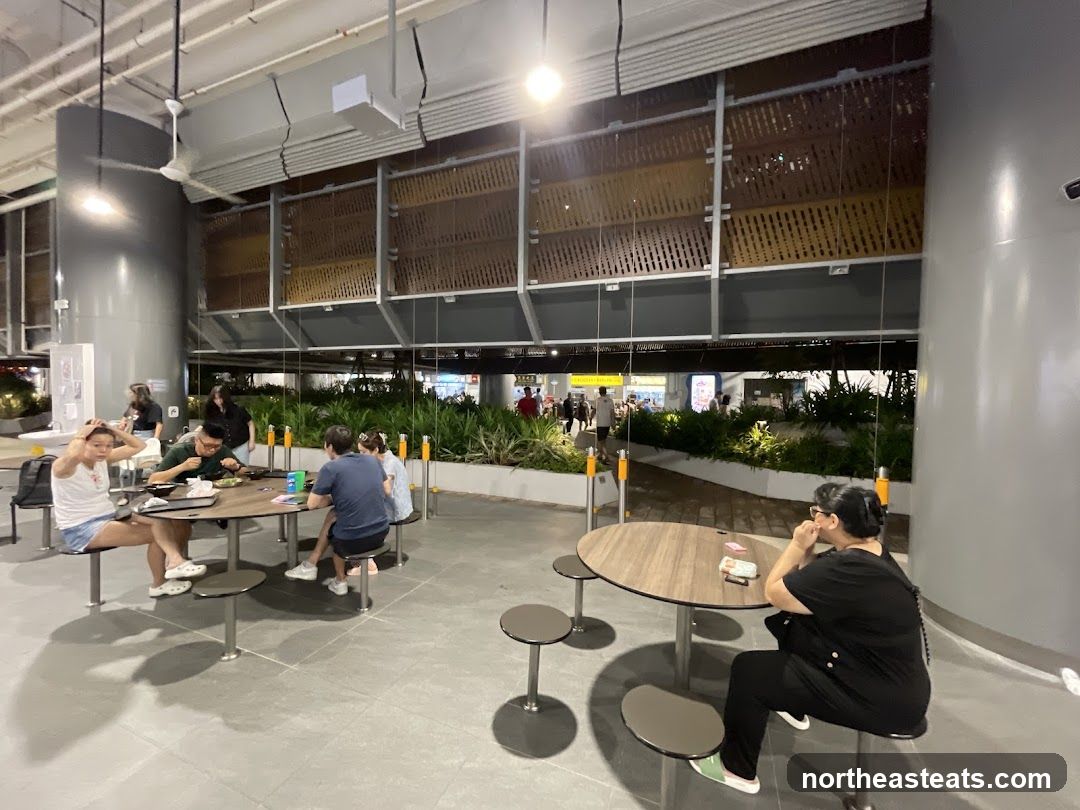 People dining at tables in an open-air food court