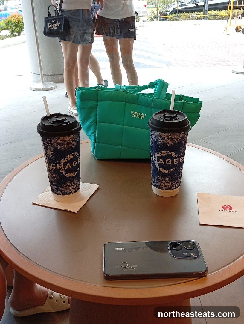 Two coffee cups and a green tote bag on a table