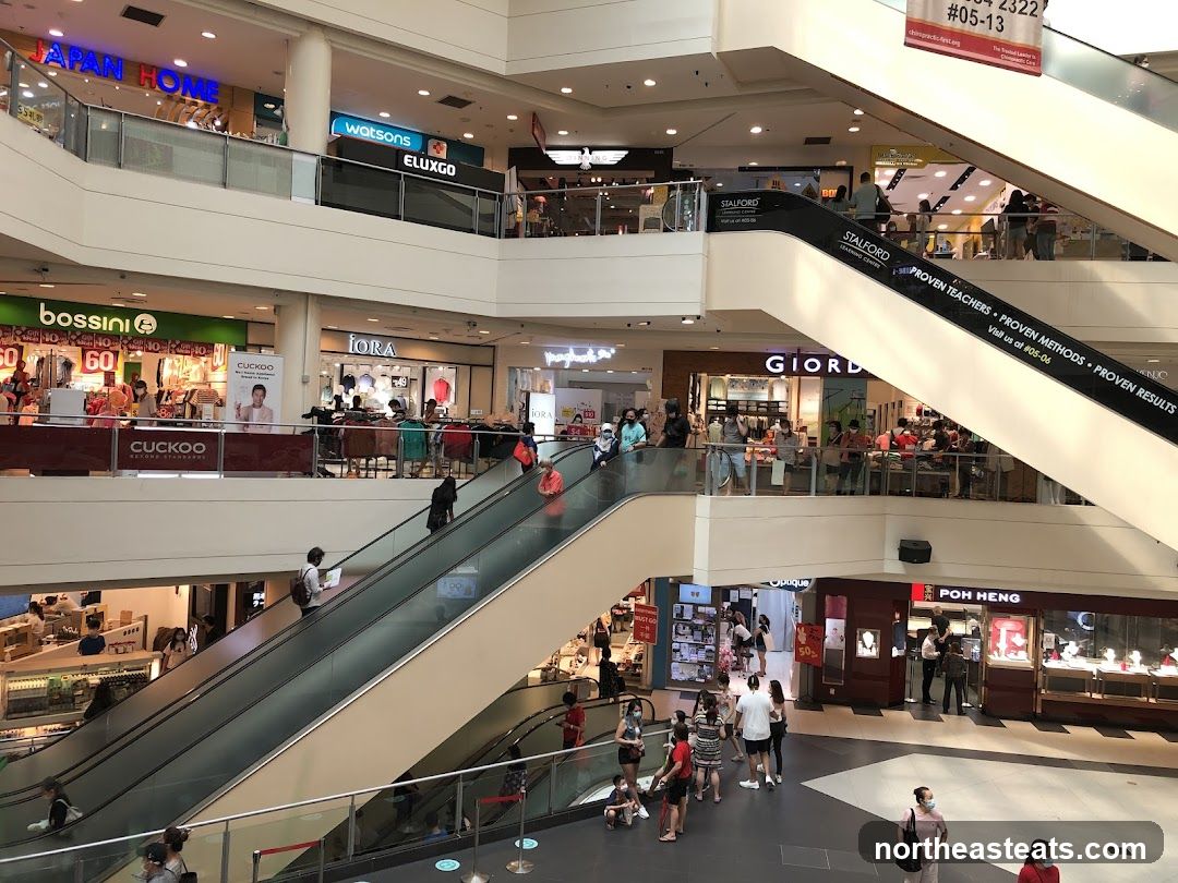 Interior of a shopping mall with escalators and various shops
