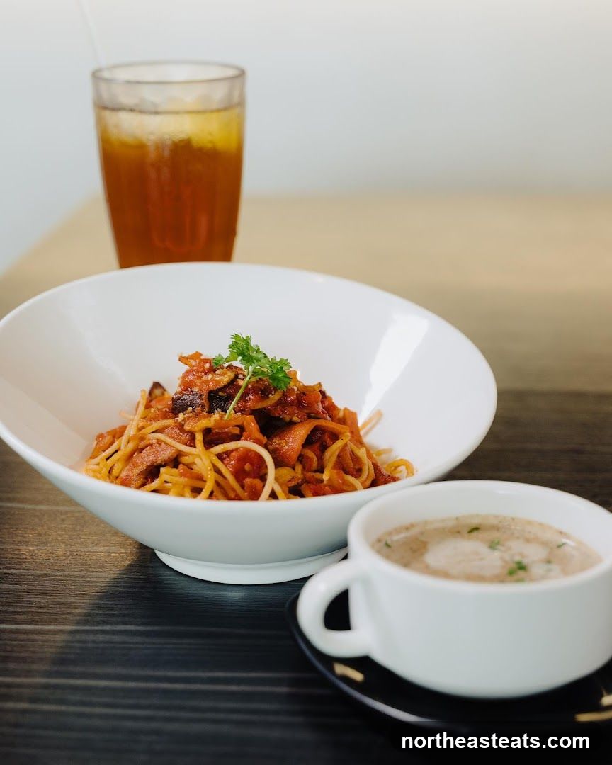 Spaghetti with a side of soup and iced tea