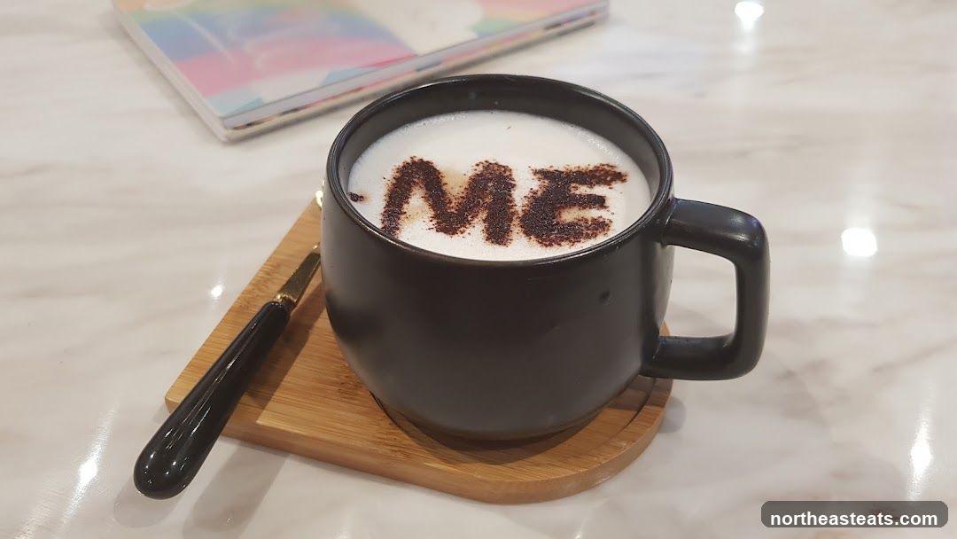 Coffee with "ME" written in cocoa powder