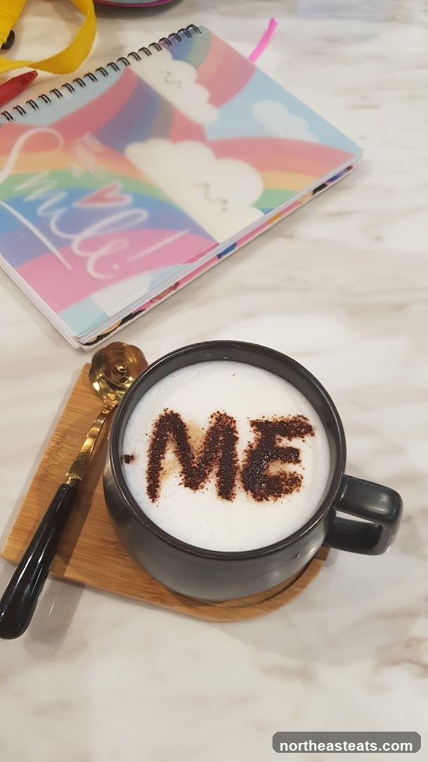 Coffee with "ME" written in cocoa powder
