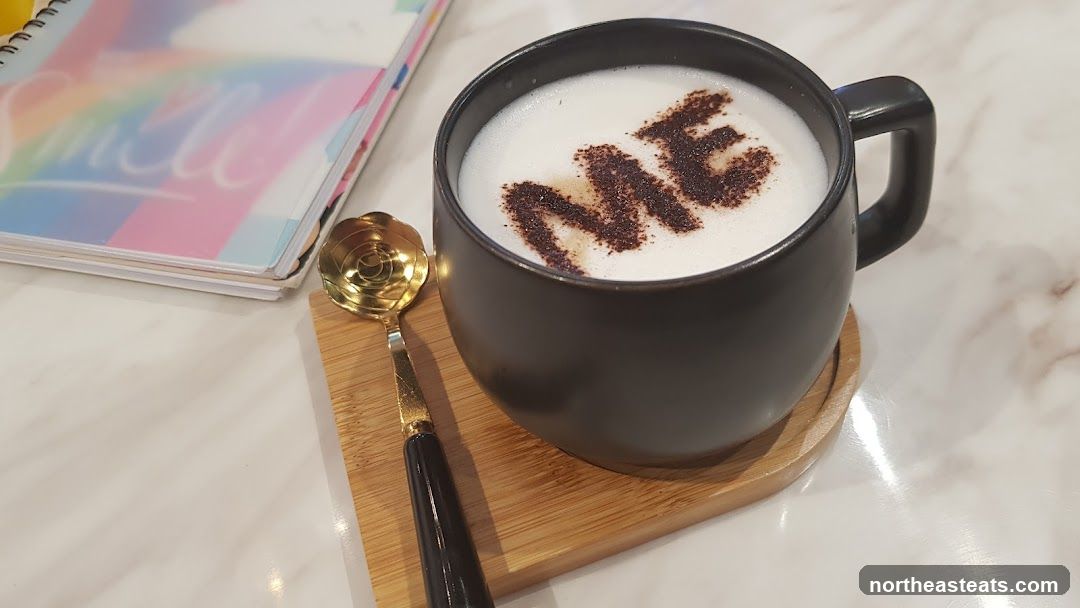 Coffee with "ME" written in cocoa powder