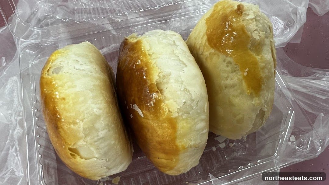 Three baked pastries in a plastic container