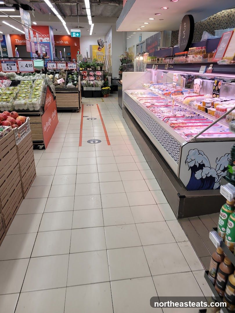 Supermarket aisle with produce and refrigerated goods