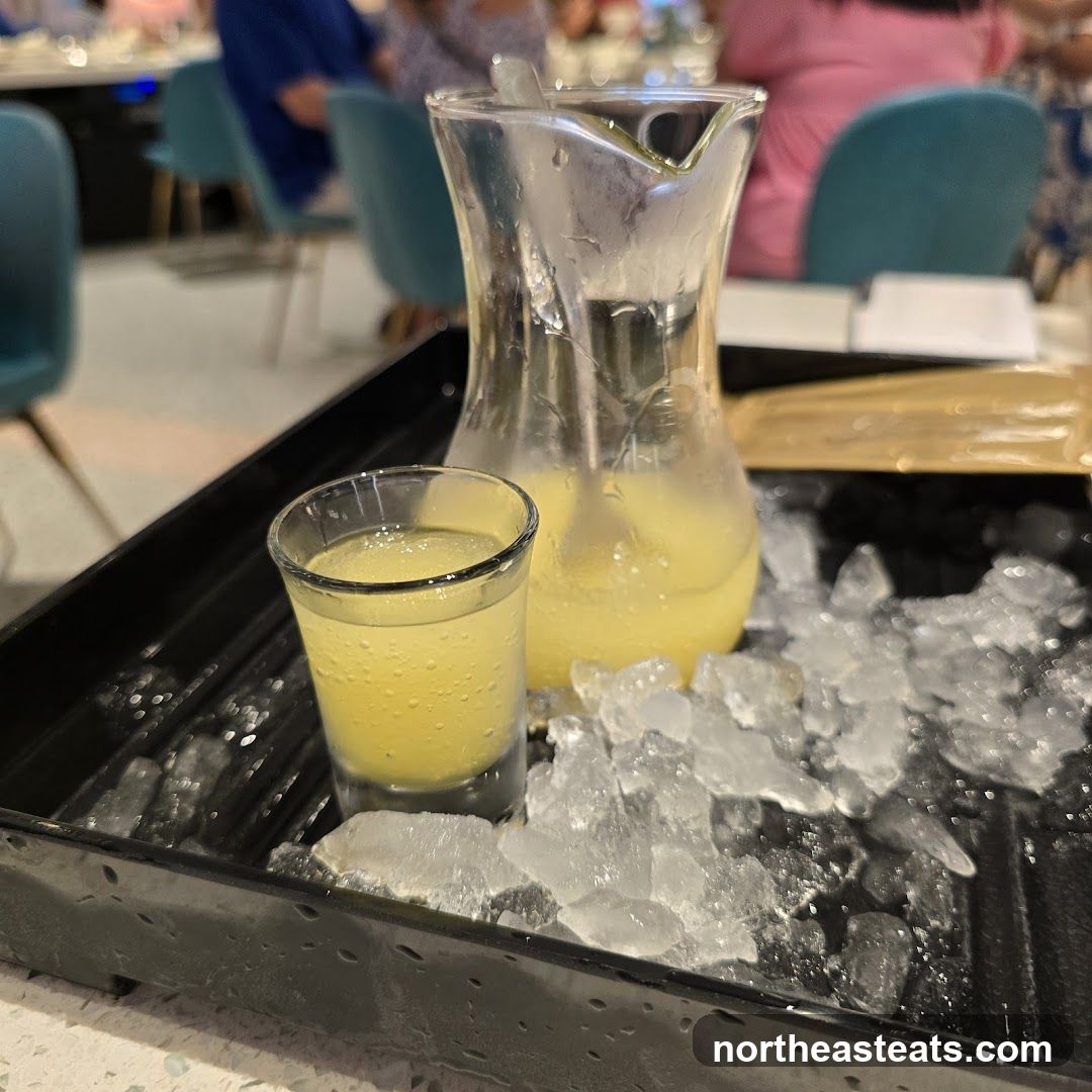 Yellow Drink in Shot Glass and Pitcher on Ice