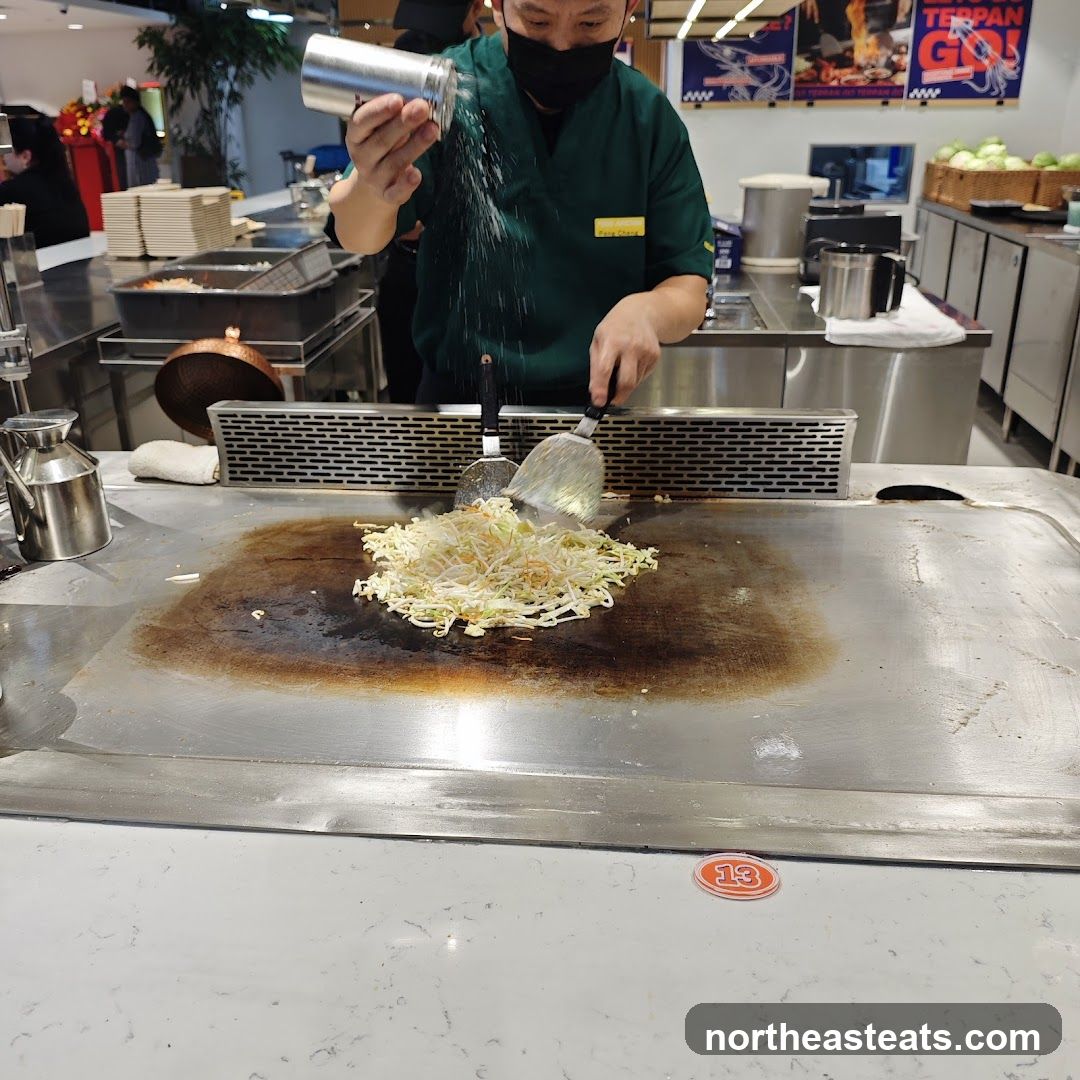 Chef cooking vegetables on a teppanyaki grill