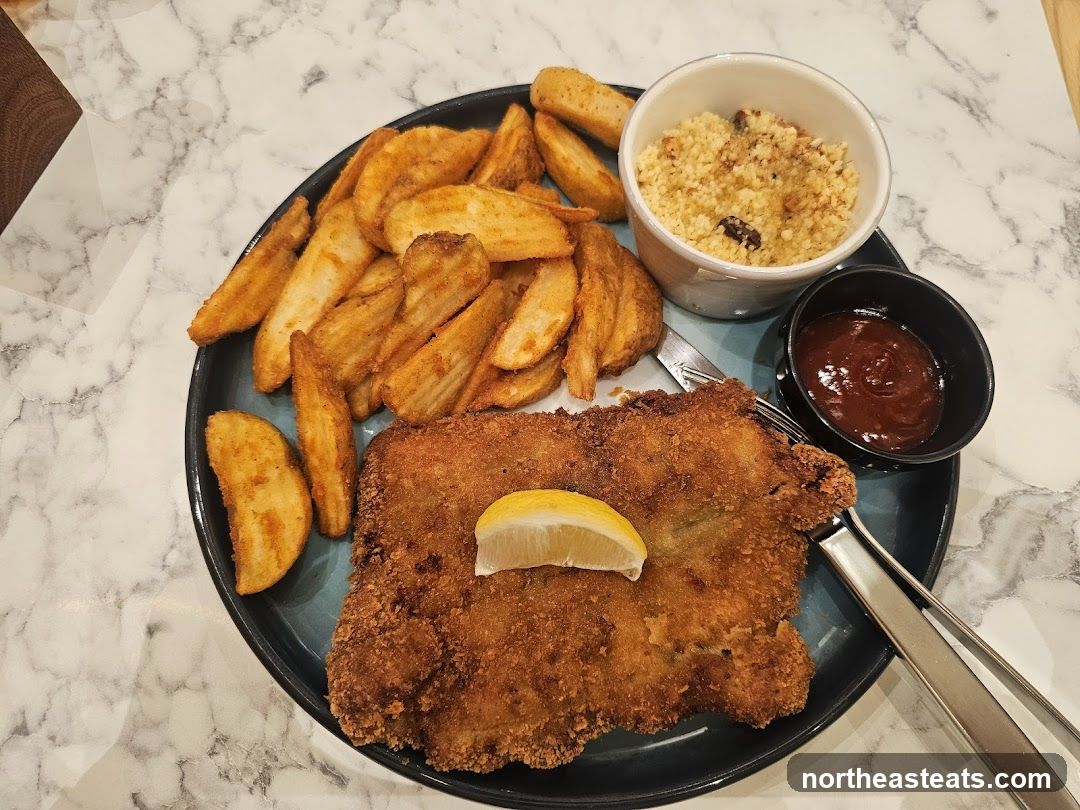 Breaded cutlet with potato wedges and sauce