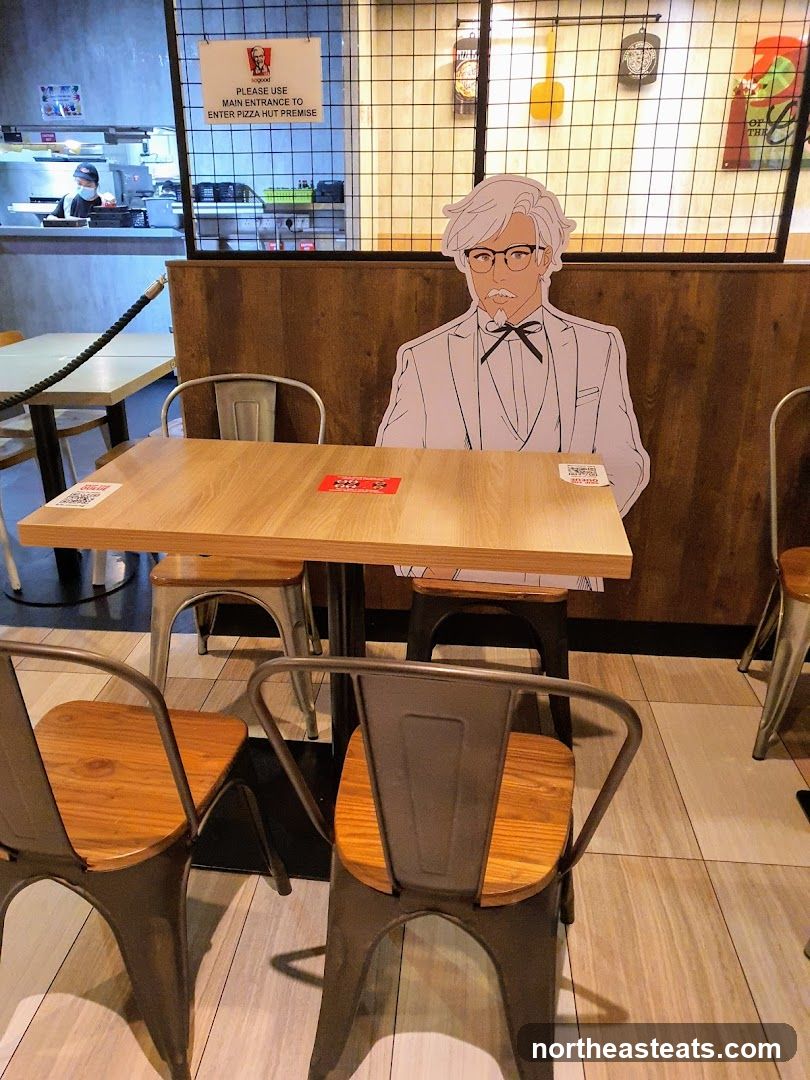 Cardboard cutout of Colonel Sanders at a table