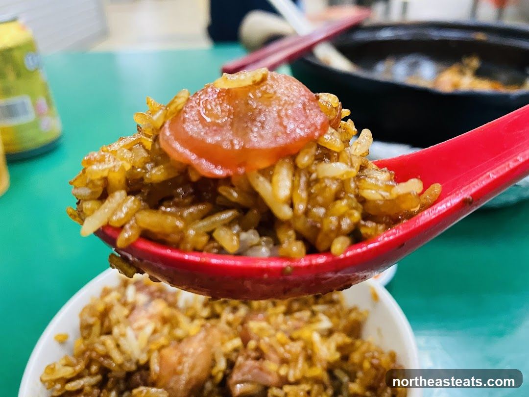 Close-up of a spoonful of fried rice with sausage