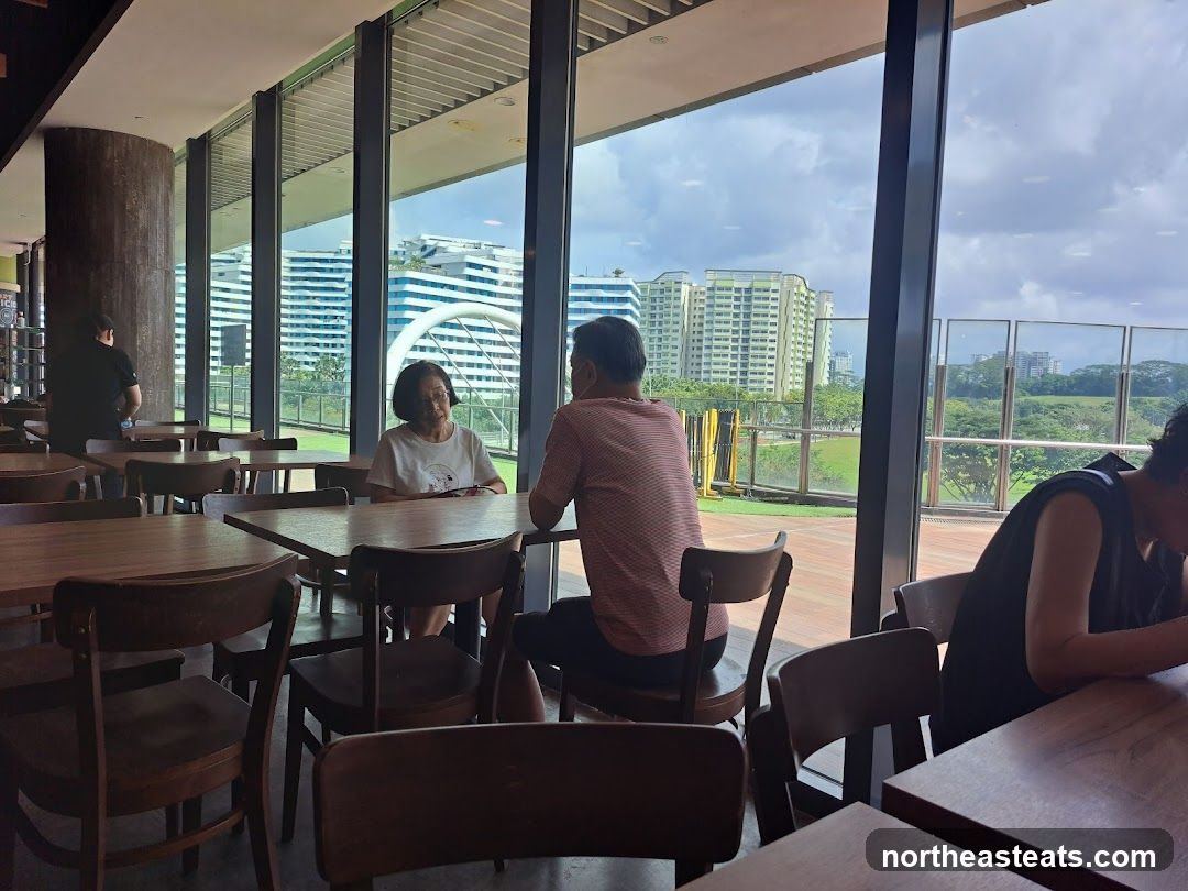 People dining at tables by large windows