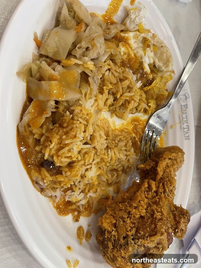 Plate of food with rice, fried chicken, and vegetables