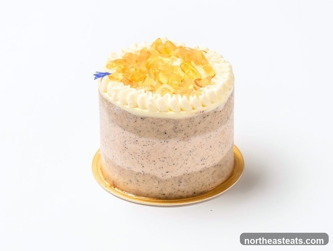 Small layered cake with white frosting and amber toppings
