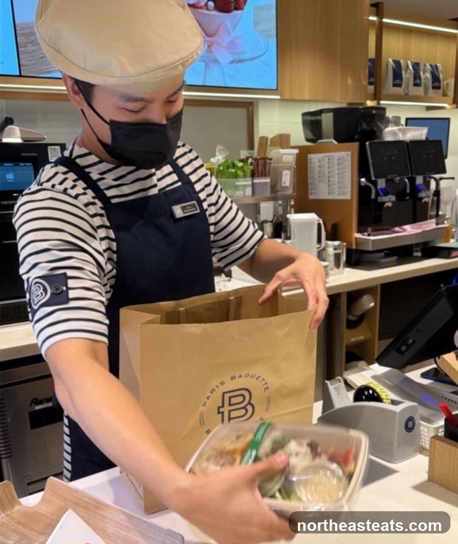 Employee packing a salad into a bag